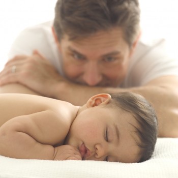 father watching his infant sleep
