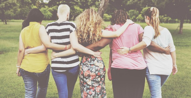 women with linked arms via Shutterstock