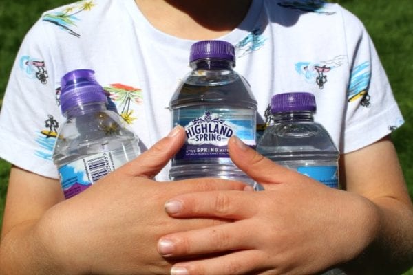 girl holding Highland Spring bottles